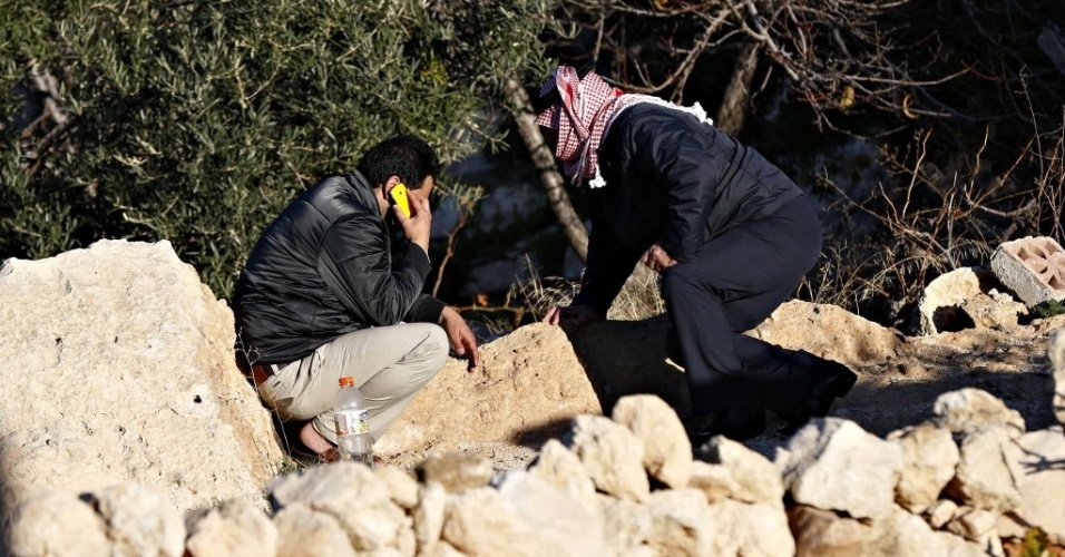 24.dez.2014 - Parentes do piloto jordaniano que teria sido capturado por combatentes do Estado Islâmico (EI) após avião ser abatido com um míssil antiaéreo na cidade de Al Raqqah, na Síria, se reúnem em frente à casa da família na cidade de Karak