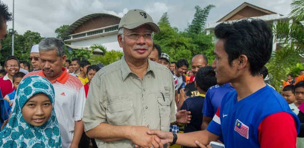 Vítimas das enchentes na Malásia cumprimentam o primeiro-ministro do país, Najib Razak (centro), após sua chegada ao centro de refúgio em Pasir Mas, nos arredores de Kota Bharu - Mohd Rasfan/AFP