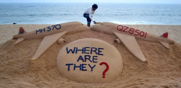 Artista Sudarshan Pattnaik finaliza escultura de areia na praia de Golden Sea, na Índia, em homenagem aos voos QZ8501, da AirAsia, e MH370, da Malaysia Airlines, que desapareceram na Ásia - AFP