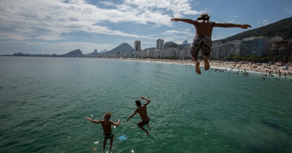 30.dez.2014 - Criancas se divertem saltando da pedra do Leme, na zona sul do Rio de Janeiro, no penúltimo dia de 2014. Com o forte calor que faz na capital fluminense, a praia é a opcão de lazer mais procurada