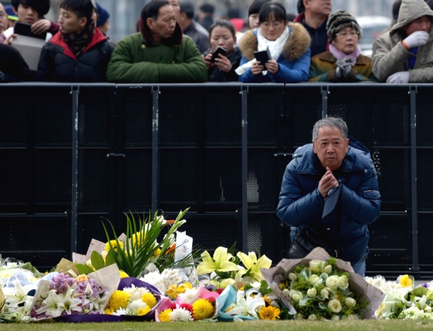 Chinês reza pelas vítimas da tragédia ocorrida durante a festa de Ano Novo em Xangai - Wang Zhao/AFP