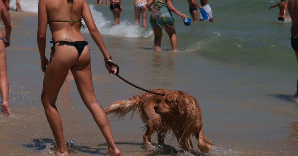 8.jan.2015 - Jovem brinca com cachorro na areia da praia do Pepê, na Barra da Tijuca, no Rio de Janeiro. A máxima prevista para esta quinta-feira (8) é de 38°C