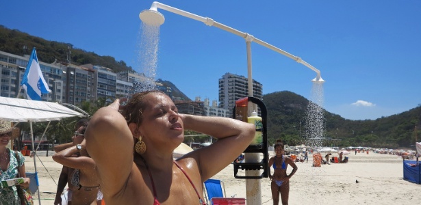 Moradora toma banho em chuveiro instalado na praia do Leme, na zona sul do Rio - Taís Vilela/UOL