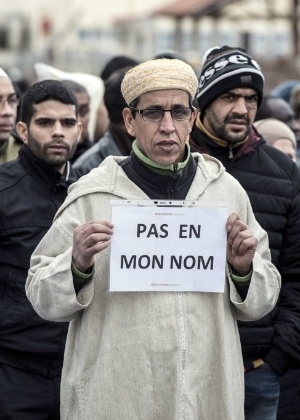 Muçulmano segura um cartaz com os dizeres "Não em meu nome" (tradução do francês) durante ato próximo à mesquita de Saint-Etienne, no leste da França - Jean-Philippe Ksiazek/AFP