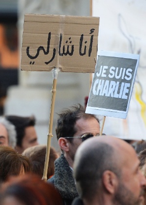 10.jan.2015 - Pessoas seguram cartazes em francês e em árabe com os dizeres ""Je suis Charlie"" (Eu sou Charlie)  - Boris Horvat/AFP