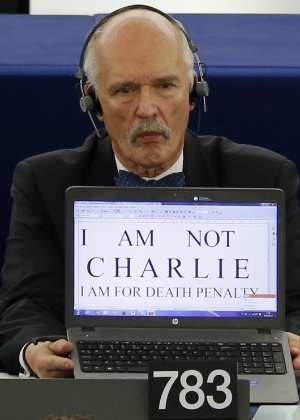12.jan.2015 - Membro do Parlamento Europeu, Janusz Korwin-Mikke, exibe o cartaz "Não sou Charlie, sou a favor da pena de morte" em Estrasburgo, na França, durante um debate sobre os atentados terroristas 