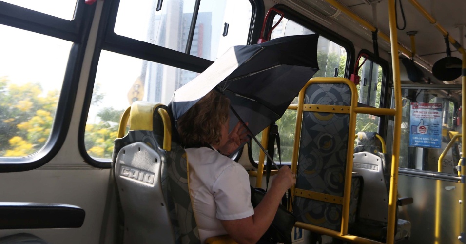 20.jan.2015 - Passageira abre sombrinha dentro do ônibus para se proteger do sol na zona sul de São Paulo, nesta terça-feira. De acordo com a Somar Meteorologia, os termômetros chegaram a atingir 35,6°C, por volta das 16h, no mirante de Santana, na zona norte. Com isso, a capital paulista chega a 15 dias seguidos registrando temperaturas acima dos 30°C