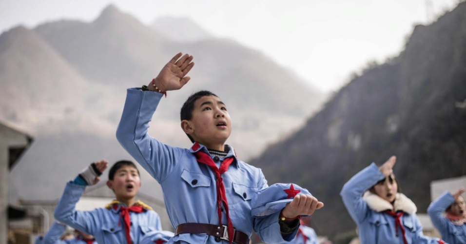 22.jan.2015 - Crianças cantam em frente a bandeira nacional chinena, na escola elementar do Exército, em Beichuan, sudoeste província de Sichuan, na China