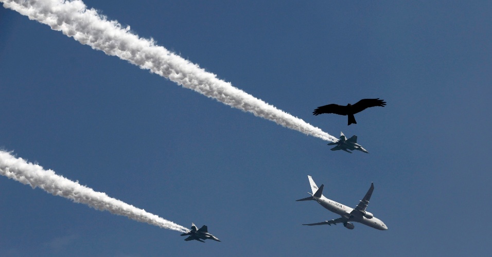 23.jan.2015 - Uma águia voa em meio aos rastros das aeronaves da Força Aérea durante o ensaio geral para o desfile do Dia da República em Nova Déli, na Índia