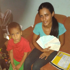 Ana Maurícia, ao lado do filho, mostra cheques encontrados no lixo - Jornal de Barretos