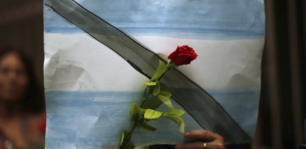 28.jan.2015 - Manifestante segura uma flor sobre um papel pintado com as cores da bandeira argentina durante uma vigília em homenagem ao promotor Alberto Nisman - Marcos Brindicci/Reuters