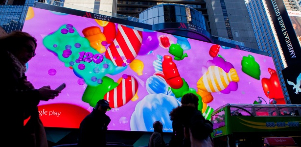 23.jan.2015 - Visitantes da Times Square caminham sob um telão digital em Nova York (EUA). A mudança da área para se tornar amigável para famílias tem sido tão bem sucedida que algumas pessoas temem que o público incomode inquilinos de escritório e frequentadores de teatros - Sam Hodgson/The New York Times