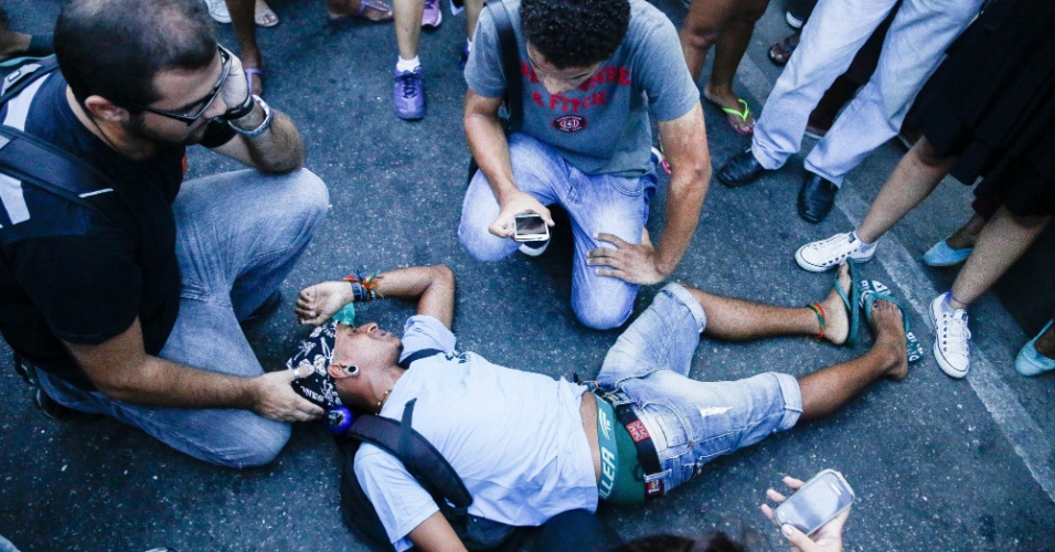 30.jan.2015 - Manifestantes acodem colega desacordado durante passeata contra o aumento das tarifas de transporte público próximo à Central do Brasil, no Rio de Janeiro. A manifestação começou na Candelária e seguiu em direção à Central do Brasil. Houve confronto entre manifestantes e policiais