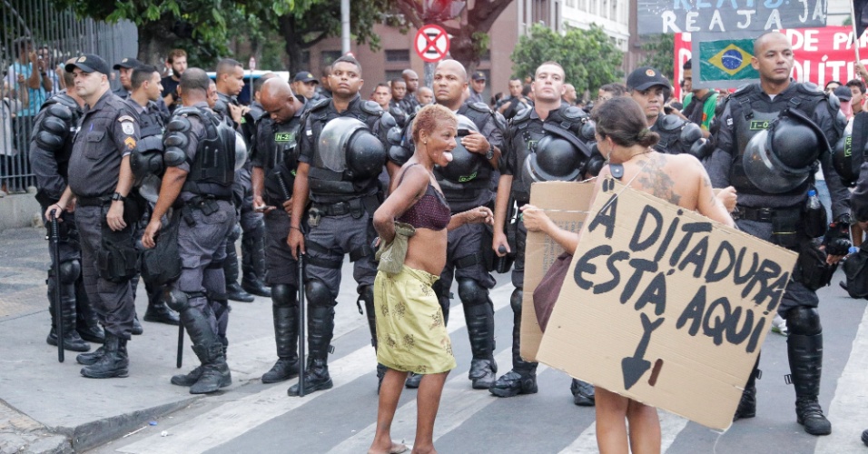 30.jan.2015 - Manifestantes exibem cartazes diante de policiais durante o protesto contra o aumento das tarifas de transporte público no Rio Janeiro. A manifestação começou na Candelária e seguiu em direção à Central do Brasil