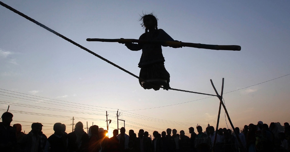 30.jan.2015 - Menina se equilibra em uma corda, nas margens do rio Ganges, na cidade de Allahabad, na Índia