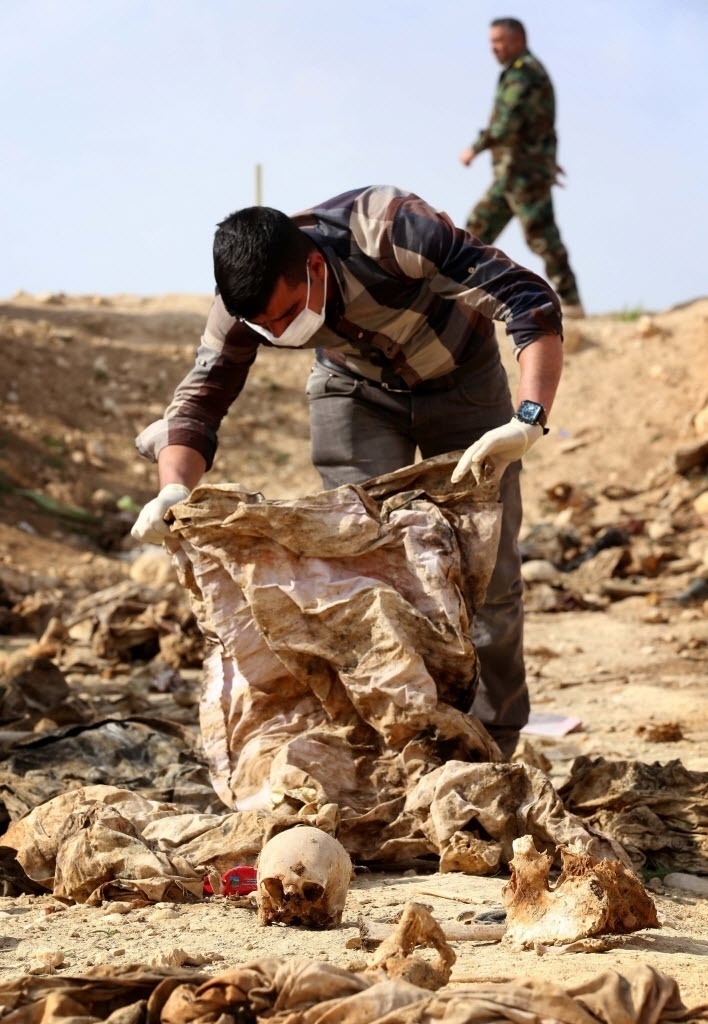 Membros da minoria Yazidi procuram por pistas em vala comum próxima da aldeia iraquiana de Sinuni, a noroeste de Sinjar, no Iraque, que levem a informações sobre parentes desaparecidos. Há suspeita de que os 25 corpos encontrados no local por forças curdas seja de curdos mortos pelo Estado Islâmico