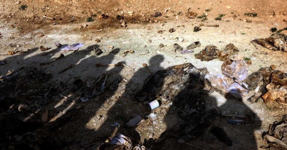 Membros da minoria Yazidi procuram por pistas em vala comum próxima da aldeia iraquiana de Sinuni, a noroeste de Sinjar, no Iraque, que levem a informações sobre parentes desaparecidos. Há suspeita de que os 25 corpos encontrados no local por forças curdas seja de curdos mortos pelo Estado Islâmico