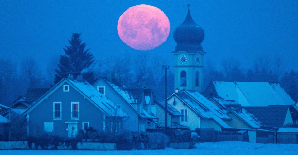 4.fev.2015 - Lua cheia avermelhada surge atrás de igreja em Regensburg, na Alemanha
