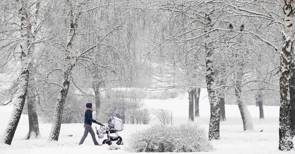 4.fev.2015 - Mulher passeia com uma criança por um parque coberto de neve em Minsk, no Belarus