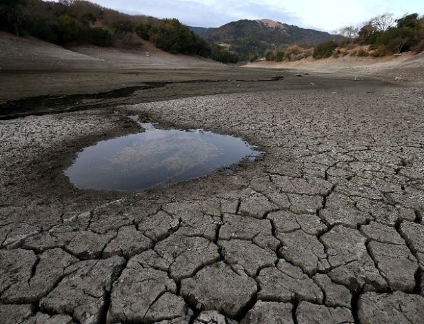 Poça de água se destaca em meio ao solo seco e rachado no fundo da represa Alamden em San Jose, na California, EUA - Justin Sullivan/Getty Images/AFP
