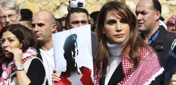 6.fev.2015 - A rainha Rania, da Jordânia, segura cartaz com retrato do piloto Maaz al-Kassasbeh e o lema "Moaz é um mártir", durante manifestação no centro de Amã
