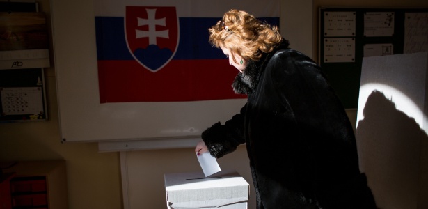 Mulher deposita voto em urna durante referendo sobre casamento entre pessoas de mesmo sexo, proibição de adoção por gays e lésbicas e por aulas de educação sexual em escolas, em Bratislava (Eslováquia)