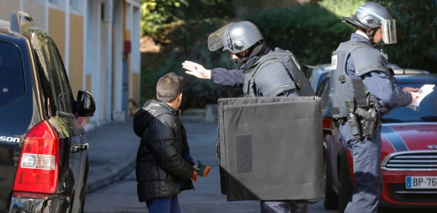 Policial orienta criança perto de escola em Marselha, na França, onde homens armados dispararam contra policiais - Jean-Paul Pelissier/Reuters