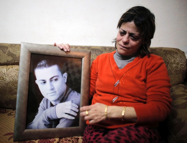 Mãe de Muhammad Musallam segura retrato do filho - Ammar Awad/Reuters