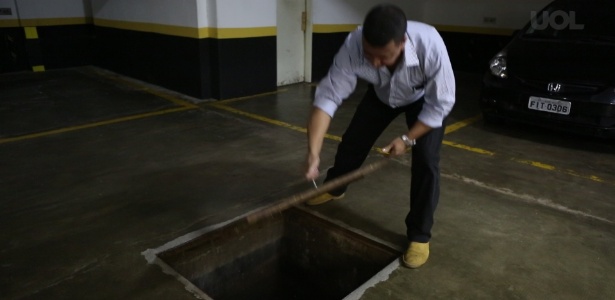 Funcionário mostra poço localizado no subsolo de prédio residencial em São Paulo - Reprodução