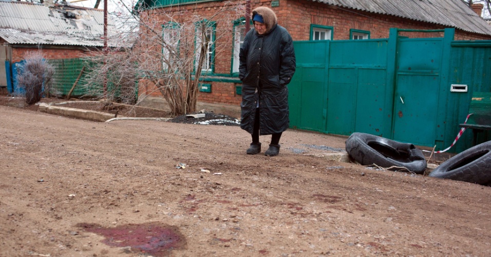 14.fev.2015 - Idosa observa, neste sábado (14), o local em que um de seus vizinhos foi morto em um bombardeio realizado por separatistas na cidade de Artemivsk, no leste da Ucrânia, na sexta-feira (13). O local é controlado por forças ucranianas. O ataque acontece a poucas horas do início do cessar-fogo, na virada de sábado para domingo