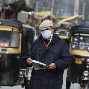  Pedestre usa uma máscara enquanto caminha por rua de Srinagar, na Índia, em fevereiro de 2015. Duas pessoas morreram e mais de 70 foram diagnosticadas com o vírus da gripe suína, o H1N1 - Farooq Khan/EFE