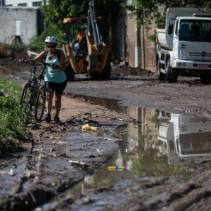 Mulher caminha em área alagada em Taboão da Serra (SP). O contato com lama e água de enchente deve ser evitado sob risco de leptospirose - Marcelo Camargo/Agência Brasil