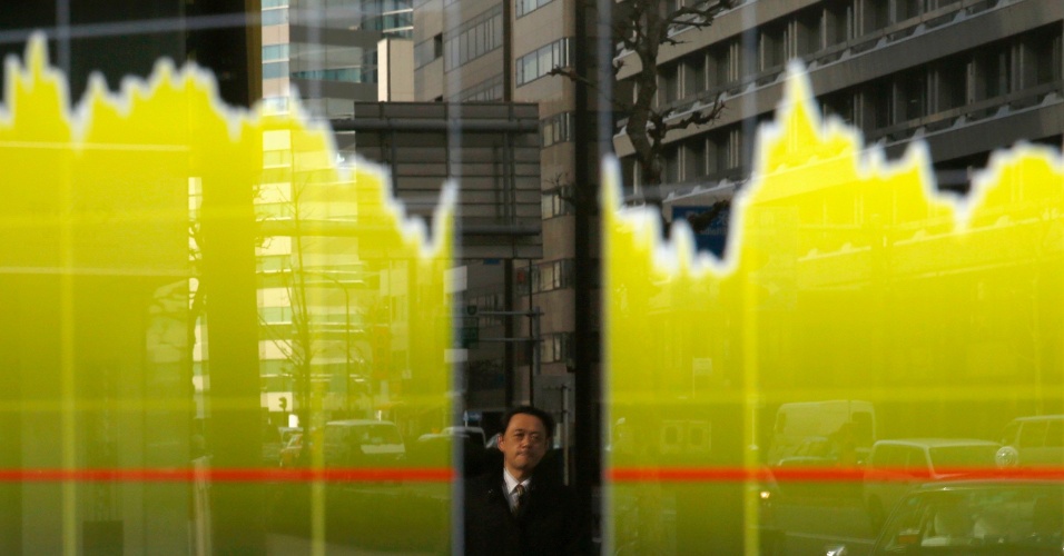 20.fev.2015 - Homem observa painel eletrônico, que registra o índice Nikkei, em uma corretora em Tóquio, no Japão