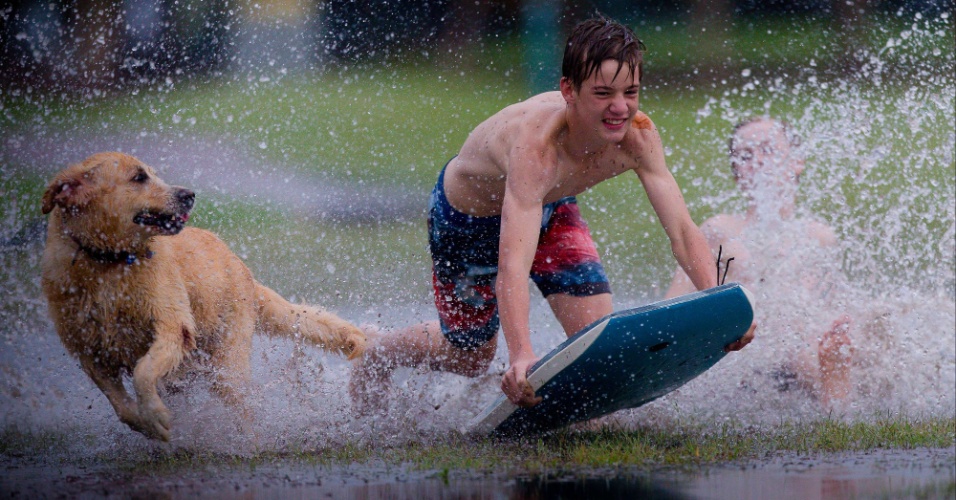 20.fev.2015 - Meninos praticam bodyboard em um parque inundado após a passagem do Ciclone Tropical Marcia em Brisbane, na Austrália