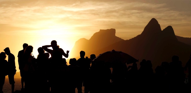 Turistas acompanham o pôr do sol na praia do Arpoador, no Rio de Janeiro