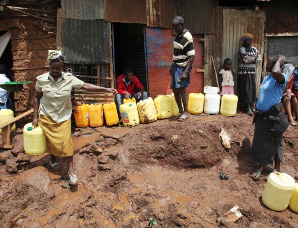 13.nov.2014 - Mulher carrega água coletada de torneira comunitária em Kibera - Katy Migiro/Reuters