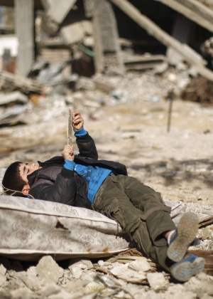 26.fev.2015 - Criança deita em destroços que restaram de ataques em Gaza em 2014