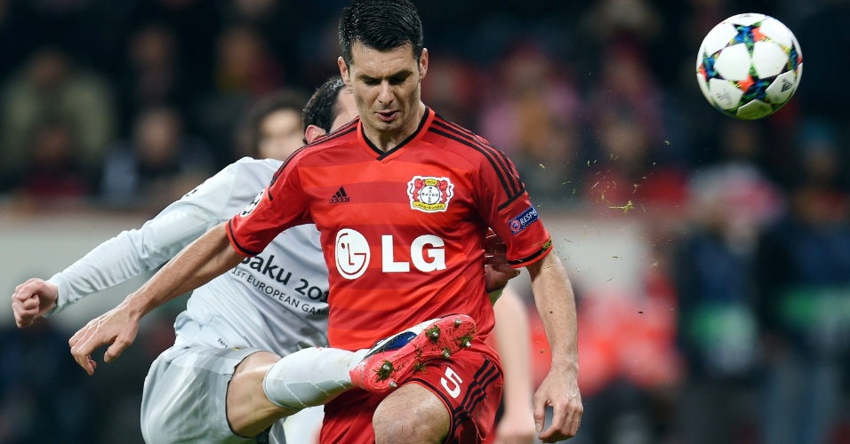 26.fev.2015 - o jogador do Atletico de Madrid Juanfran e o jogador do Leverkusen Emir Spahic (dir.) disputam bola durante a partida da Champions League, em Leverkusen, na Alemanha