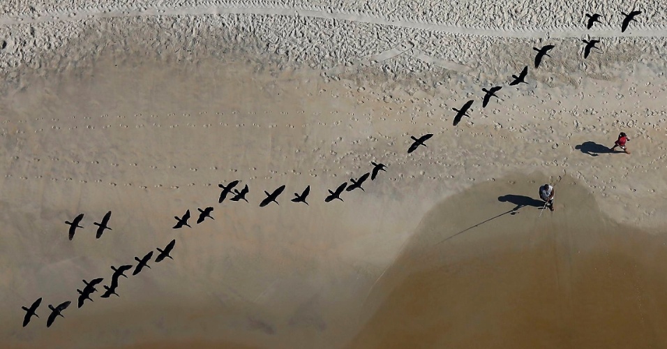 26.fev.2015 - Pássaros, pescador e pedestre são vistos do alto a partir de helicóptero, na praia de São Conrado, no Rio de Janeiro