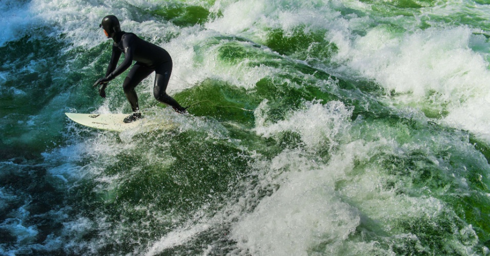 26.fev.2015 - Surfista pega onda usando roupa de neoprene, no rio Eisbach, na Alemanha