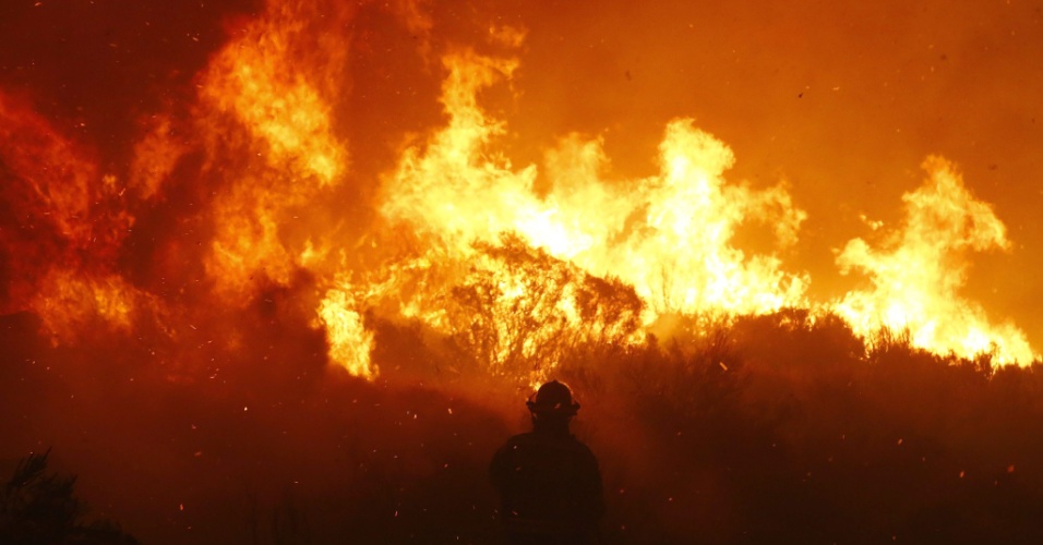 2.mar.2015 - Um bombeiro tenta conter incêndio em Noordhoek Manor (lar de idosos), na Cidade do Cabo, na África do Sul