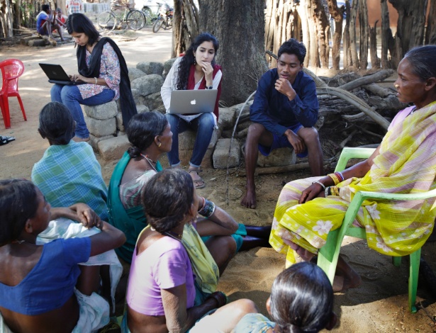 Parijata Bharadwaj e Guneet Kaur, do grupo de ajuda jurídica, com moradores do vilarejo - Kuni Takahashi/The New York Times