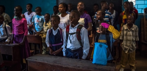 De luvas rosas, James Nyema, 9, canta o hino da Libéria na escola de ensino fundamental C.D.B. King, na capital Monróvia - Daniel Berehulak/The New York Times