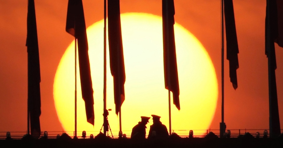 5.mar.2015 - Dois militares ficam de guarda sob bandeiras vermelhas no telhado do Museu Nacional durante o nascer do sol, antes da sessão de abertura do Congresso Nacional do Povo (NPC) em Pequim, na China