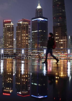 Mulher caminha no cais the Bund em frente ao distrito financeiro de Pudong, em Xangai - Aly Song/Reuters