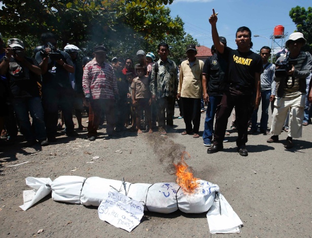 Grupo queima estátua simulando corpo humano perto da balsa que leva à ilha-prisão de Nusakambangan, na Indonésia - Darren Whiteside/Reuters