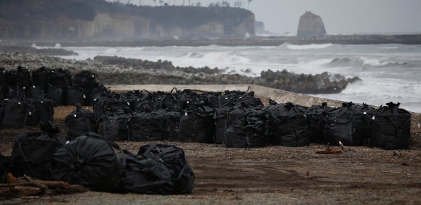 Sacos plásticos contendo terra, folhas e destroços contaminados são colocados perto do mar, na cidade de Tomioka, região de Fukushima, perto da usina nuclear. A foto é de março de 2015 - Toru Hanai/Reuters