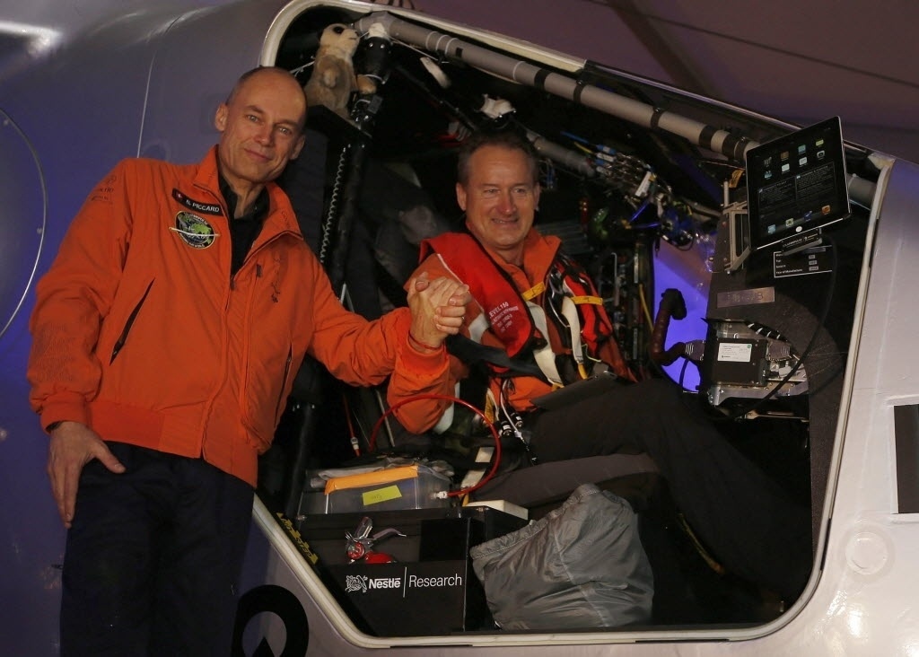9.mar.2015 - 9.mar.2015 - Os pilotos suíços Bertrand Piccard (à esquerda) e Andre Borschberg se cumprimentam antes de decolareM com o avião Solar Impulse 2 do aeroporto de Al Bateen, em Abu Dhabi, nos Emirados Árabes. Ambos tentam o primeiro voo ao redor do mundo em um avião movido a energia solar. O próximo destino da aeronave é Mascate, capital de Omã. Este é o início de uma viagem de 35 mil km que terá duração de cinco meses - Ali Haider/EFE