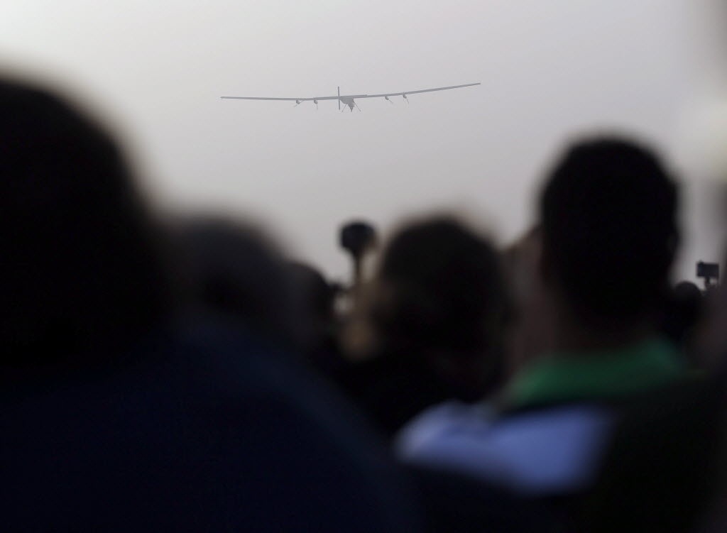 9.mar.2015 - Pessoas observam o avião Solar Impulse 2 decolar no aeroporto de Al Bateen, em Abu Dhabi, nos Emirados Árabes. O próximo destino da aeronave é Mascate, capital de Omã. Os pilotos suíços Bertrand Piccard e Andre Borschberg tentam o primeiro voo ao redor do mundo em um avião movido a energia solar. Este é o início de uma viagem de 35 mil km que terá duração de cinco meses - Ali Haider/EFE