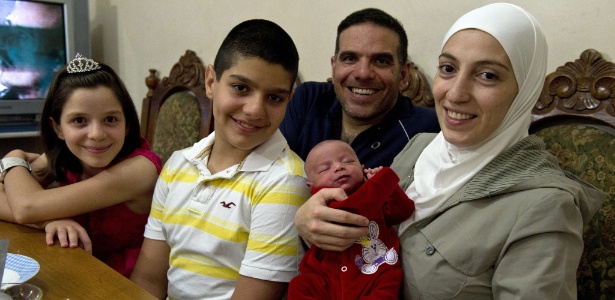 Talal Al Tinawi posa para foto com sua mulher, Ghazal, e os filhos do casal, Yara (esq), Riad e Sara (bebê) em São Paulo - Nelson Almeida/AFP